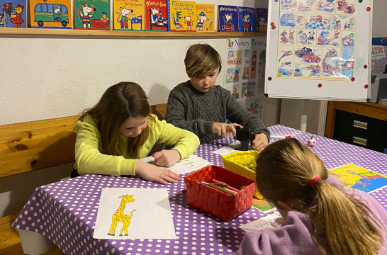 kids coloring and learning at the table